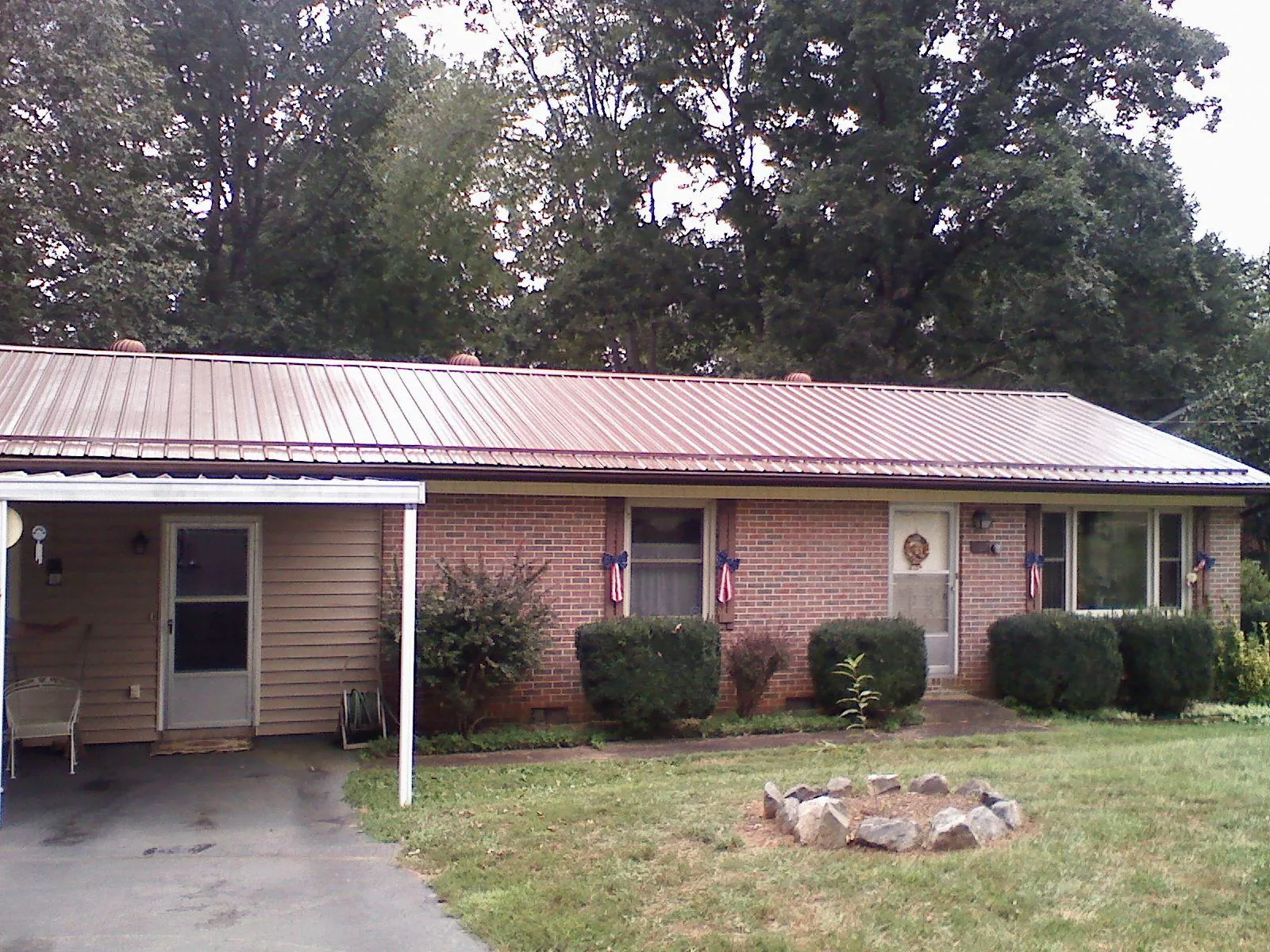 Bronze metal roof and carport on a brick ranch home — Roof Repair work by our crew in Quail Valley